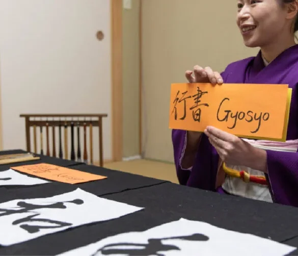 A split-screen illustration showing two conversation scenarios. On the left, a business meeting with people in suits around a table, a speech bubble saying “Keiei no jyokyo o mite kimemasu” (We’ll decide after checking business conditions). On the right, two friends sitting at a café, laughing, with a speech bubble saying “Jyokyo shidai da ne” (Depends on the situation).