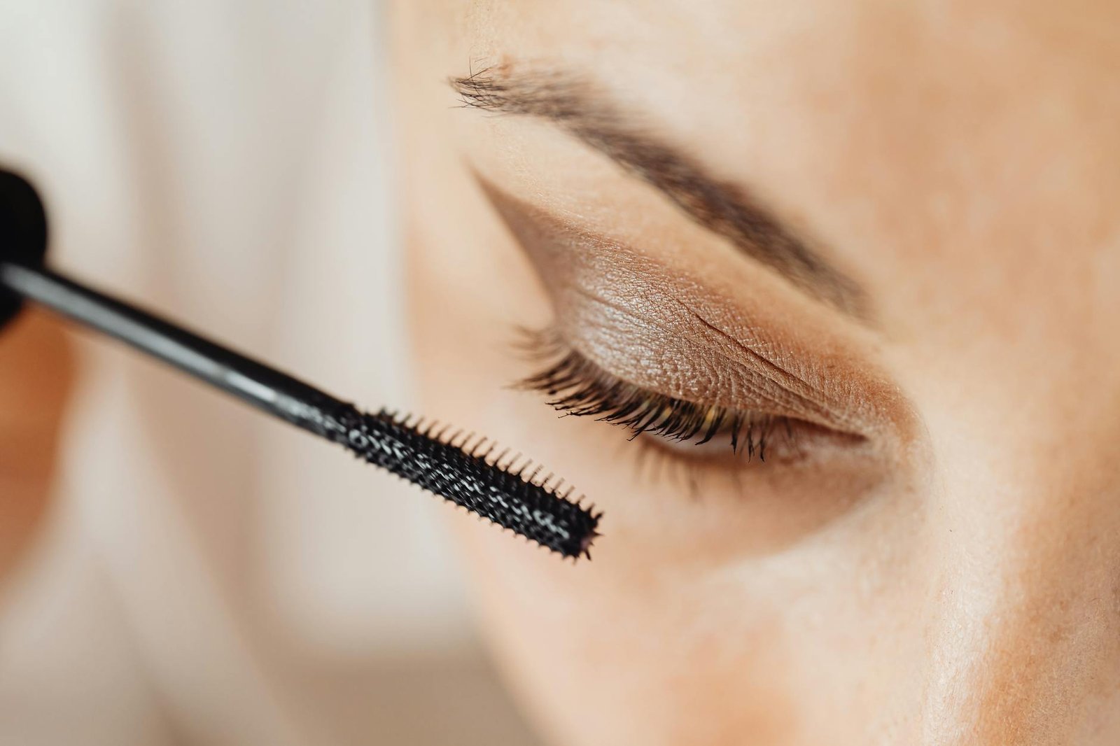 beauty trends and tips - Detailed close-up of mascara application on eyelashes with eyeshadow.