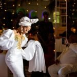 celebrity fashion moments - Bride in white dress gracefully dancing at a vibrant wedding celebration with joyful guests.