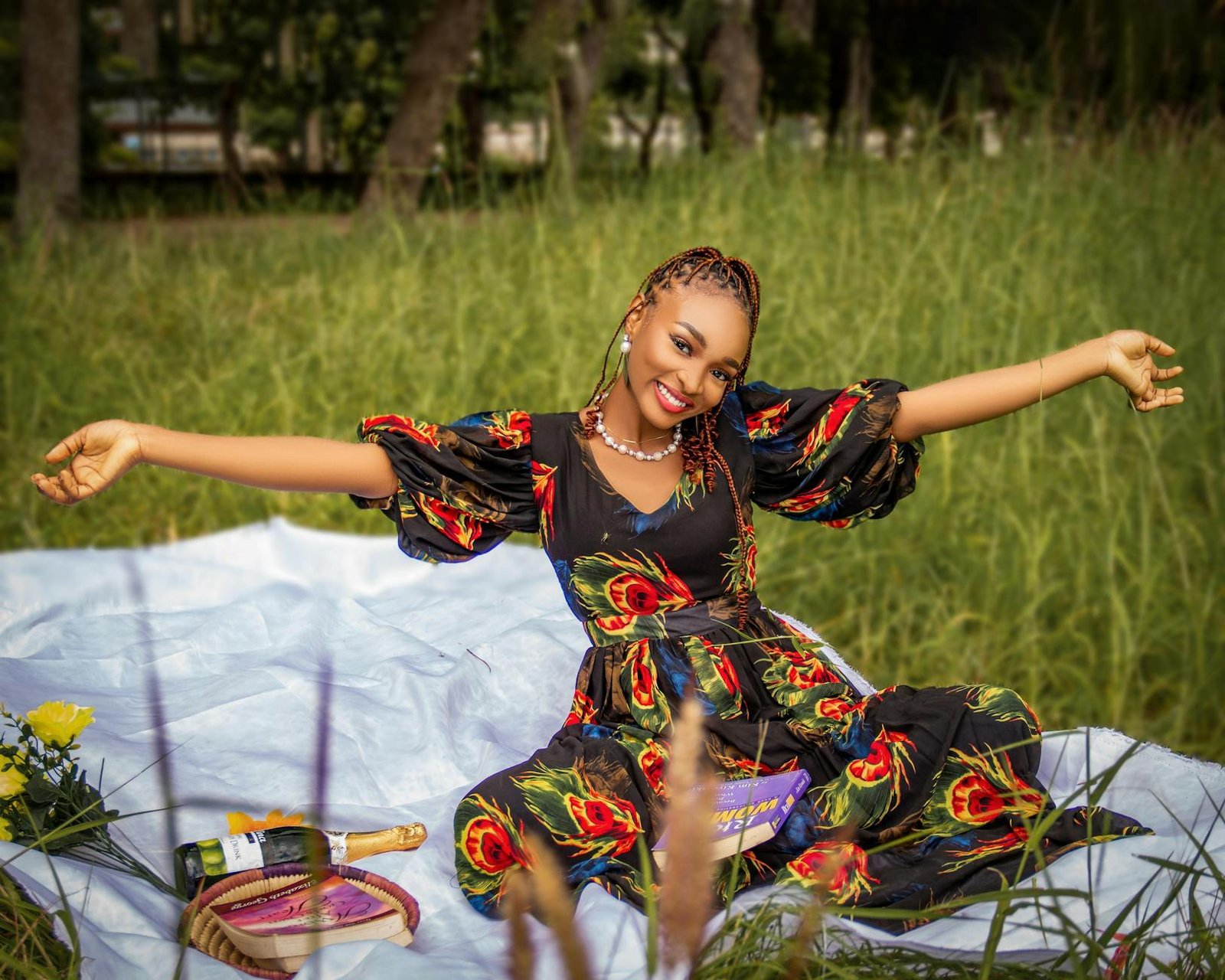 celebrity fashion moments - A joyful woman enjoying a picnic in a summer field, celebrating with champagne and flowers.