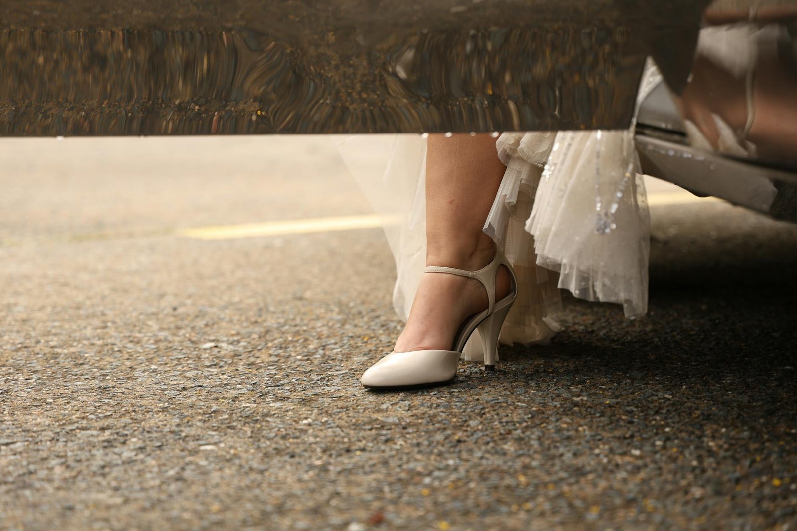 celebrity fashion moments - Elegant bride steps out of car, showcasing footwear and gown details.