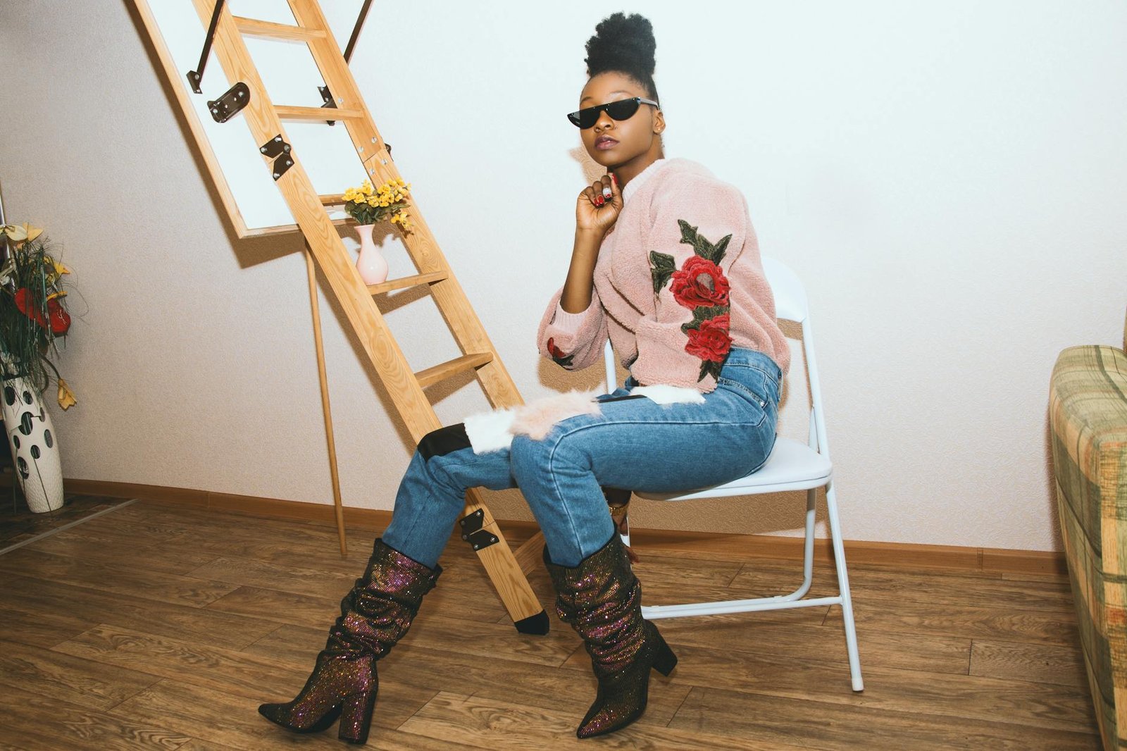 celebrity style inspiration - Elegant woman in a chic outfit posing indoors with sunglasses and stylish boots.