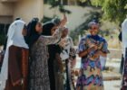 fashion culture and society - A joyful group of women in colorful attire enjoying a sunny day outdoors.