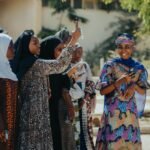 fashion culture and society - A joyful group of women in colorful attire enjoying a sunny day outdoors.