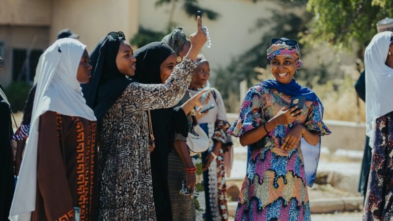 fashion culture and society - A joyful group of women in colorful attire enjoying a sunny day outdoors.