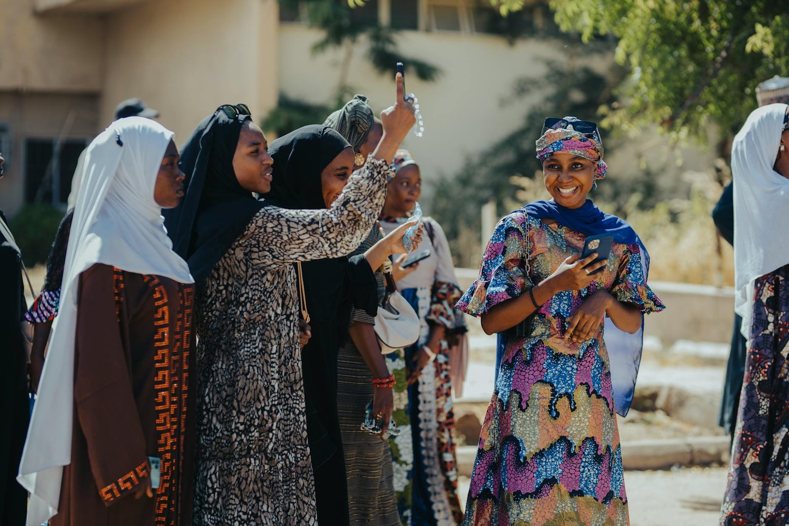fashion culture and society - A joyful group of women in colorful attire enjoying a sunny day outdoors.