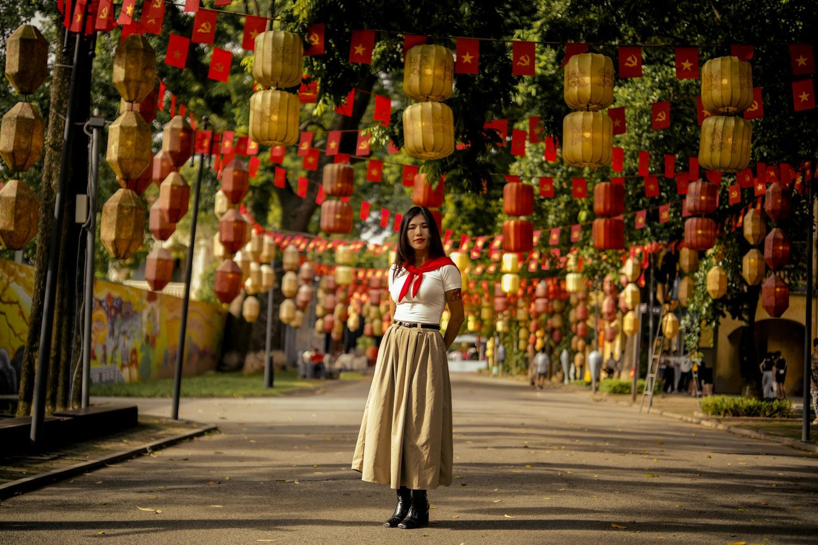 fashion culture and society - A woman stands on a decorated street with lanterns and flags, embodying cultural celebration.