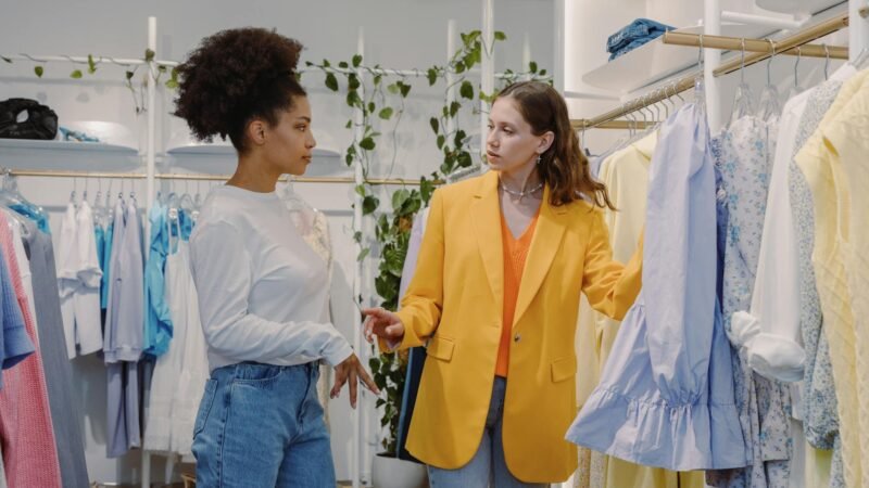 fashion trends and career advice - Two women in a boutique store browsing clothes, discussing styles.