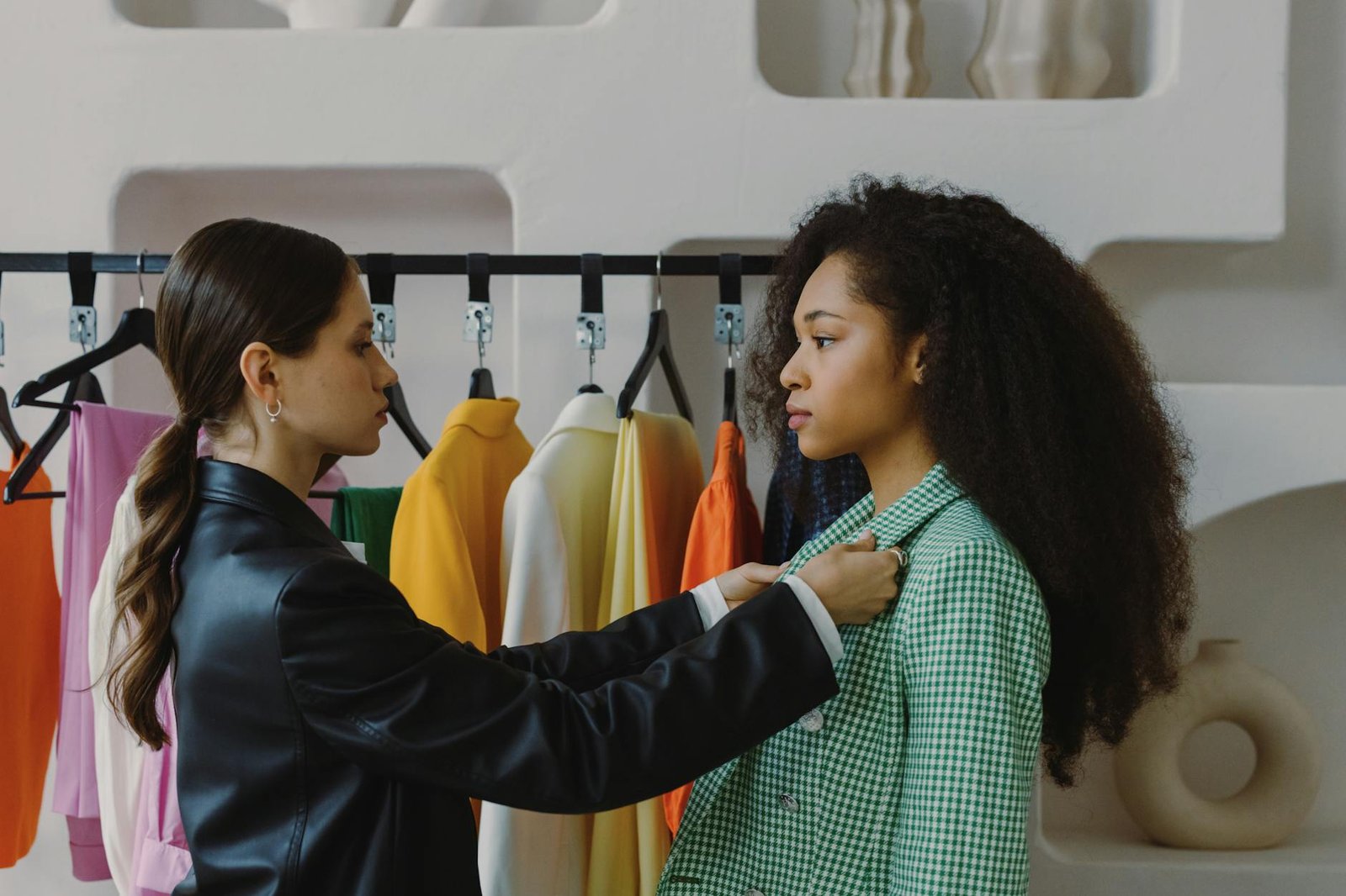 fashion trends and career advice - Fashion stylist adjusts outfit for model in chic boutique.