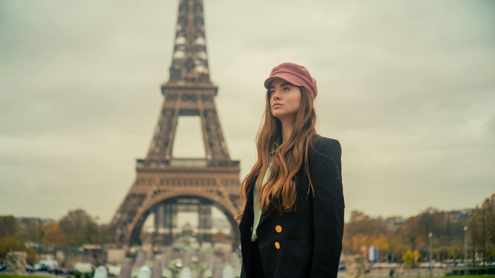 french style inspiration - Elegant young woman in Paris posing with a chic look by the Eiffel Tower.