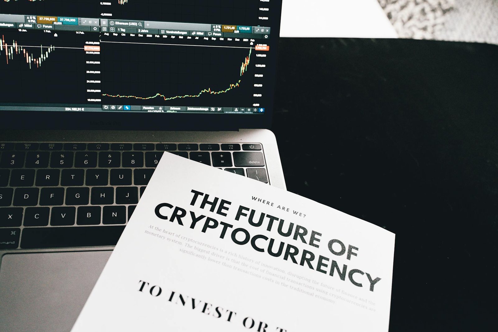 how to invest in crypto - A detailed look at cryptocurrency market trends using a laptop and analytical document.