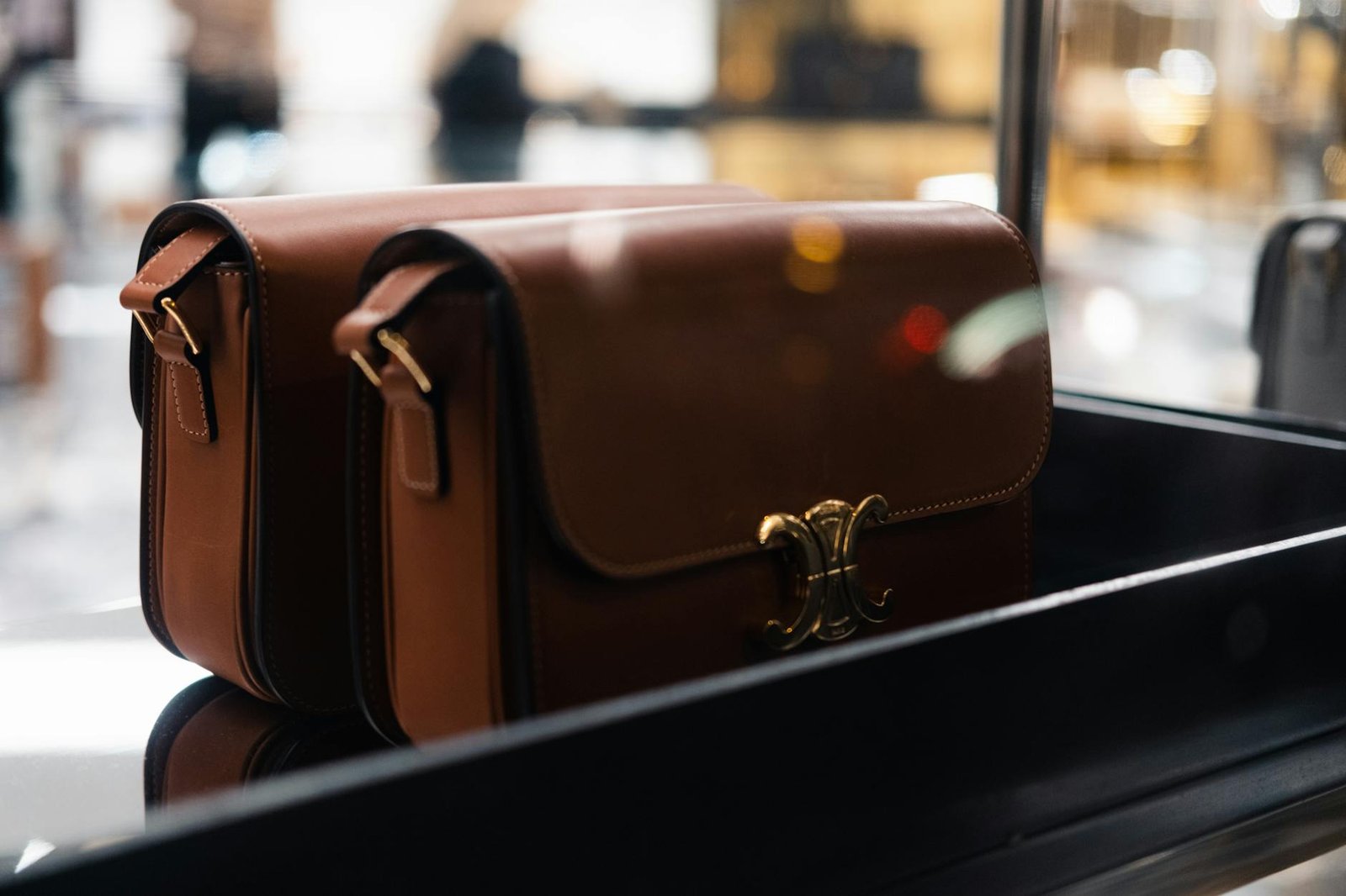 luxury lifestyle fashion trends - Stylish brown leather handbags showcased indoors with soft focus lights.