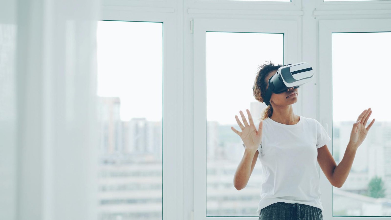 technology - A woman enjoying a virtual reality experience with VR headset indoors.