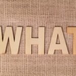 what is fintechzoom - Wooden letters forming the word WHAT set on a textured burlap surface.