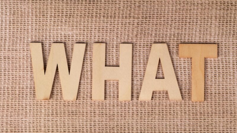 what is fintechzoom - Wooden letters forming the word WHAT set on a textured burlap surface.